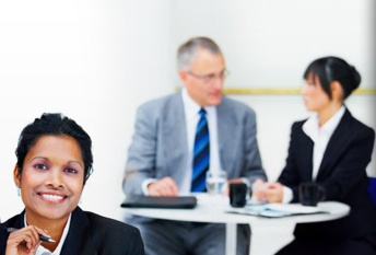 Business woman standing in front of office colleagues